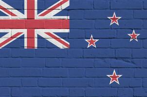 New Zealand flag depicted in paint colors on old brick wall. Textured banner on big brick wall masonry background photo