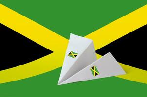 Jamaica flag depicted on paper origami airplane. Handmade arts concept photo