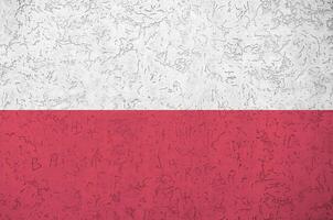 Poland flag depicted in bright paint colors on old relief plastering wall. Textured banner on rough background photo