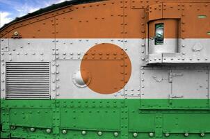 Niger flag depicted on side part of military armored tank closeup. Army forces conceptual background photo