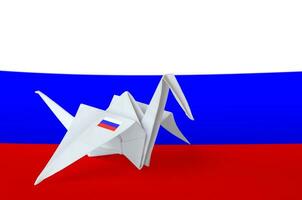 Russia flag depicted on paper origami crane wing. Handmade arts concept photo