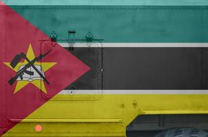 Mozambique flag depicted on side part of military armored truck closeup. Army forces conceptual background photo