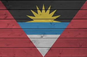 Antigua and Barbuda flag depicted in bright paint colors on old wooden wall. Textured banner on rough background photo