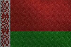 Belarus flag depicted in paint colors on old brushed metal plate or wall closeup. Textured banner on rough background photo