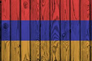 Armenia flag depicted in bright paint colors on old wooden wall. Textured banner on rough background photo