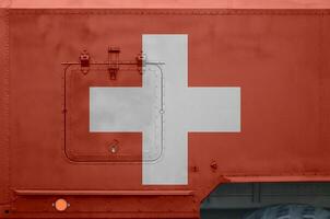 Switzerland flag depicted on side part of military armored truck closeup. Army forces conceptual background photo