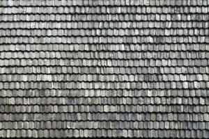 Gray wooden roof tiles background texture. A close up of old gray roof covered with wooden tiles photo