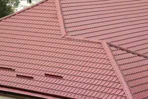 Decorative metal roof tiles in shape of old shingles. Type of roof of the house from a metal profile photo