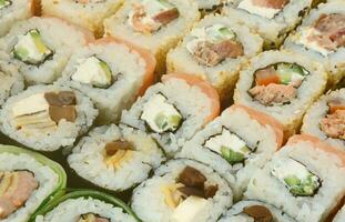 Close-up of a lot of sushi rolls with different fillings. Macro shot of cooked classic Japanese food. Background image photo