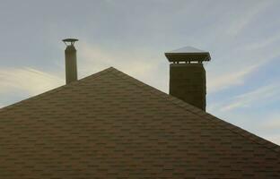 The roof covered with a modern flat bituminous waterproof coating under a blue sky photo