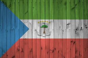 Equatorial Guinea flag depicted in bright paint colors on old wooden wall. Textured banner on rough background photo