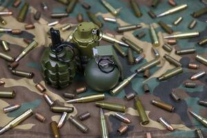 Different types of ammunition on a camouflage background. Preparing for war photo