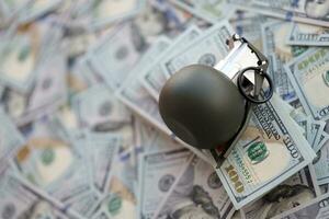 Grenade with a check against the background of huge amount of american dollar bills photo