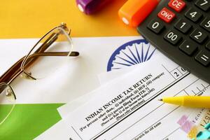 Indian income tax return blank form with pen and indian rupees bills photo