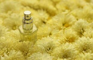 Women fragrance perfume bottle with flowers background close up. Unnamed blank sprayer bottle of perfume photo