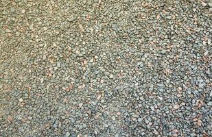 Close up of muddy puddle with small stones on wet surface. Background texture with top view photo