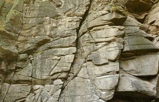 Light coarse natural rock stone background. Mining cliff rough front surface. Big limestone stack backdrop. Heavy grunge damaged granite block texture photo