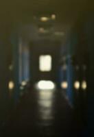 The blurred image of gloomy corridor of a neglected public building. Defocused picture of a public space in a poor residential high-rise building photo
