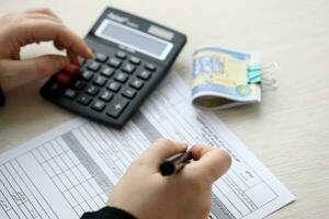 Accountant start to fill Iranian tax form on office table. Taxation period and annual taxpayers routine photo