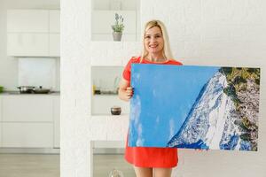 woman holds canvas at home photo