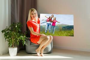 woman holds photo canvas at home