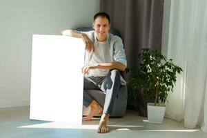 man holds photo canvas at home