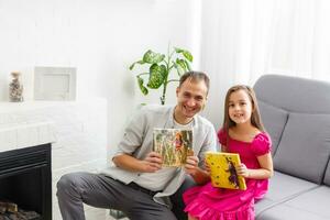 father and daughter hold photo canvas in the interior