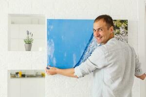 man holds canvas in the interior photo