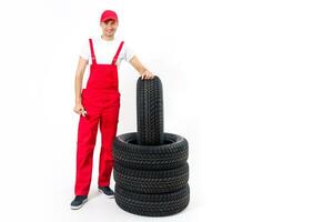 trabajando hombre en lleno crecimiento sostiene un neumático en un blanco antecedentes foto