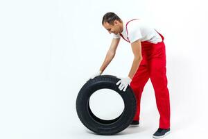 Mechanic holding a tire tire at the repair garage. replacement of winter and summer tires. photo