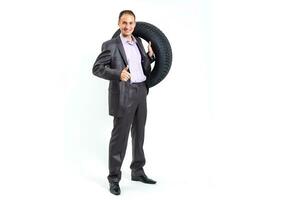 Car dealer man over tire tire background. Auto maintenance. photo