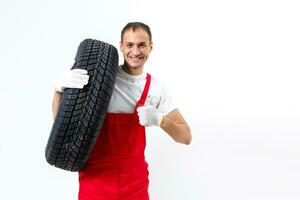 Mechanic carrying a tyre on a white background photo