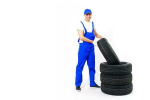 trabajando hombre en lleno crecimiento sostiene un neumático en un blanco antecedentes foto