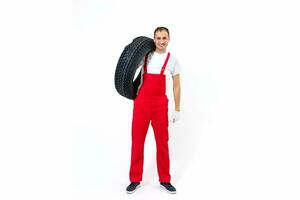 Portrait of smiling male mechanic holding tire on white background photo