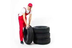 trabajando hombre en lleno crecimiento sostiene un neumático en un blanco antecedentes foto