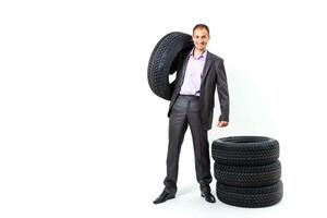 Car dealer man over tire tire background. Auto maintenance. photo