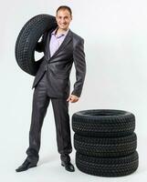 Car dealer man over tire tire background. Auto maintenance. photo
