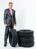 Car dealer man over tire tire background. Auto maintenance. photo