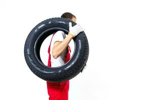 Mechanic carrying a tyre on a white background photo