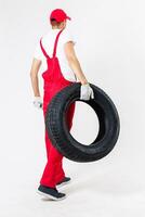 Mechanic holding a tire tire at the repair garage. replacement of winter and summer tires. photo