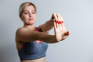 Beautiful Dieting Fat Woman who practices Fitness for Weight Loss Does Stretching Exercises on an Isolated Background with Space for Advertising photo