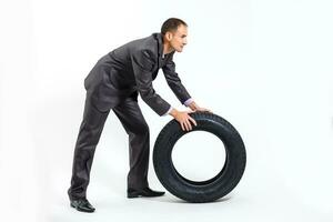 Car dealer man over tire tire background. Auto maintenance. photo