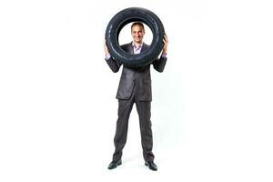 Car dealer man over tire tire background. Auto maintenance. photo