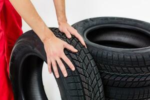 Mechanic Holding Car Tire on a white background photo