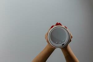 Female hand with paper cup isolated on white photo