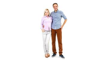 Smiling young couple embracing and standing full length isolated on white background photo