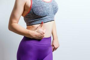 Beautiful Dieting Fat Woman who practices Fitness for Weight Loss Does Stretching Exercises on an Isolated Background with Space for Advertising photo