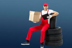 Mechanic Holding Car Tire on a white background photo