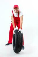 working man in full growth holds a tire on a white background photo