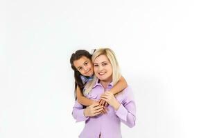 Cheerful mother giving piggyback ride to her daughter against a white background photo